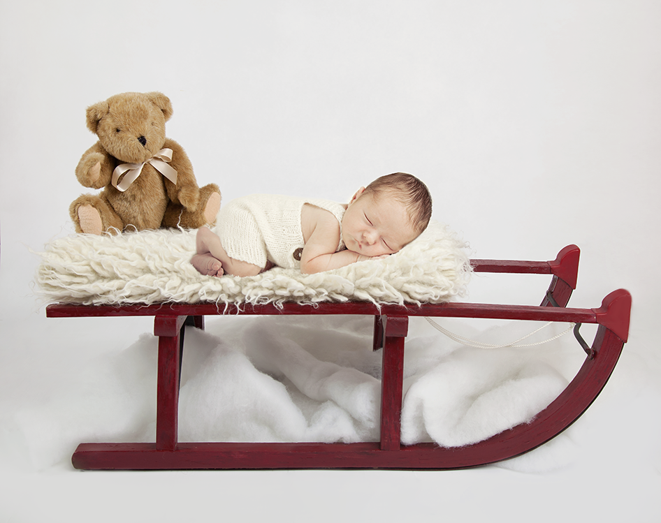 red sledge with teddy and baby